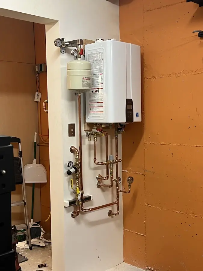 Plumbing technician inspecting water heater connections in Augusta